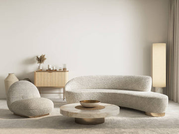 Modern living room with a curved sofa, armchair, and side table.